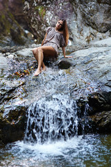 Sexy woman laying near a waterfall