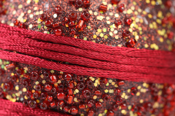 Background of beads and red threads.