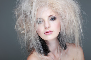 portrait of sexy whiteheaded young woman with blue eyes on grey 