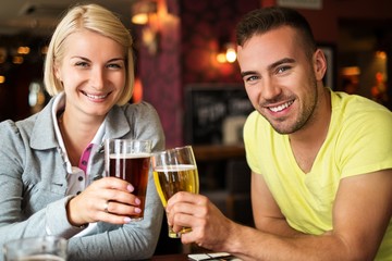 Beautiful couple enjoying beer in a pub