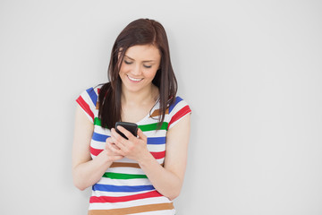 Smiling girl using her mobile phone