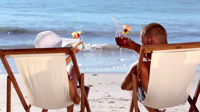 Couple drinking cocktail on the beach