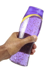 Hand holding transparent shampoo bottle