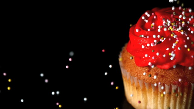 Sprinkles falling onto a cupcake