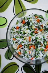Vegetarian rice salad in a glass bowl on colorful background