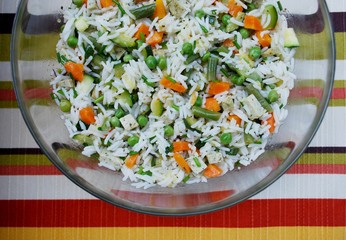 Vegetarian rice salad in a glass bowl on colorful background