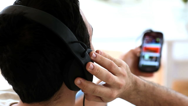 Man moving his head while listening to music with his phone