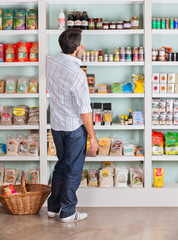 Thoughtful Man Choosing Products In Supermarket