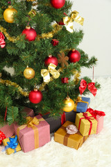 Decorated Christmas tree with gifts on grey wall background