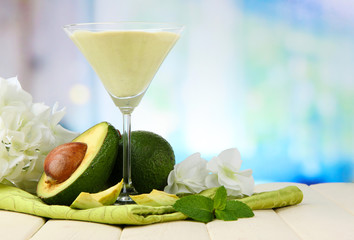 Fresh avocado smoothie on bright background