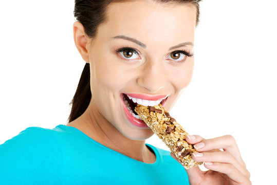 Young Woman Eating Cereal Candy Bar