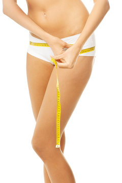 Slim fit woman in white panties with measure tape