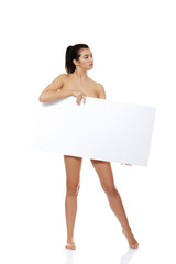 Sexy naked brunette holding empty board