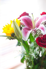 Fototapeta premium beautiful bouquet of sunflowers, lily and roses in a vase