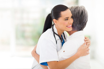 young medical doctor hugging senior patient