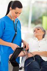 Obraz premium medical doctor checking senior patient's blood pressure