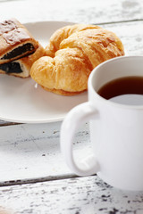 Close up tea mug and baked croissant