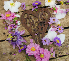Rostiges Herz mit Blüten auf Holz