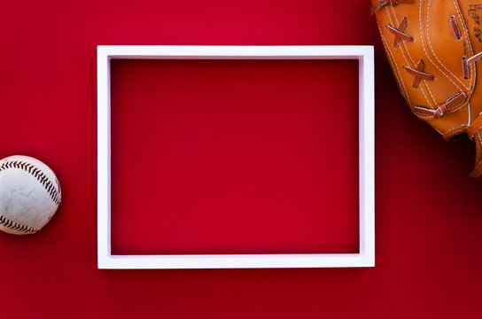 Empty Picture Frame On A Red Wall With Baseball Equipment