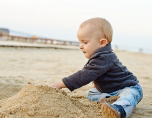 baby boy playing in sand