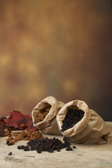 Golden and black raisins in paper bags on a wooden table