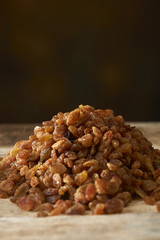 Golden raisins over wooden table