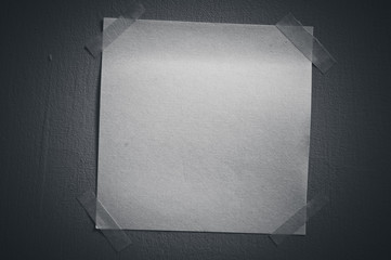 A blank sticky note with a notebook on the wall 