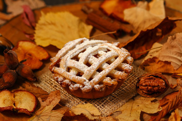 Apple pie with cinnamon on wood table