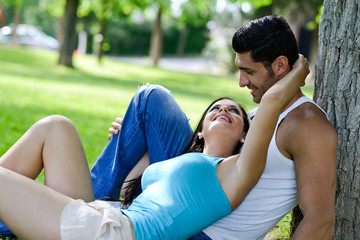 Happy smiling couple laying on green grass