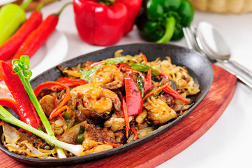 Spicy fried seafood on a hot pan.