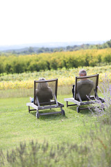 Fototapeta premium Senior people relaxing in long chairs in countryside
