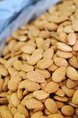 Heap of raw almonds nuts background