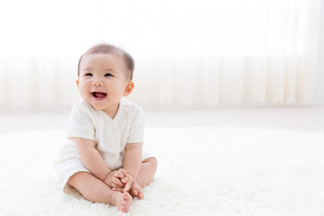 asian baby relaxing on the carpet