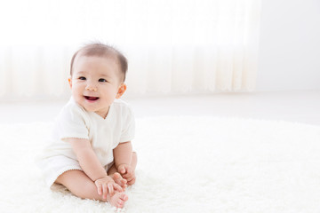 asian baby relaxing on the carpet