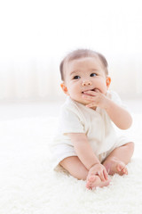 asian baby relaxing on the carpet