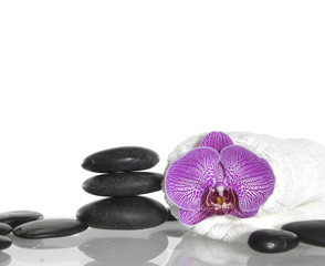 pink orchid with towel and stacked stones
