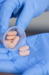 Medicine tablets on hands with glove