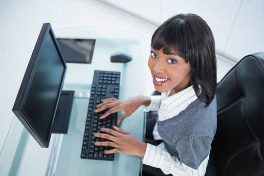 High angle view of smiling pretty businesswoman typing