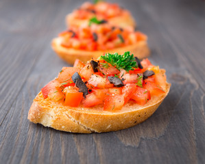 Tomato bruschetta topped with olive