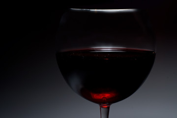 Dark atmospheric image of red wine in a glass