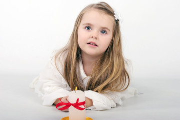 A beautiful little girl angel with a candle