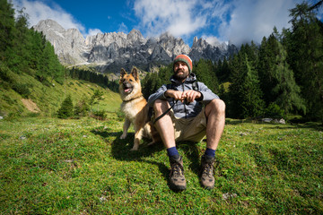 Lachender Mann mit seinem Hund macht Pause