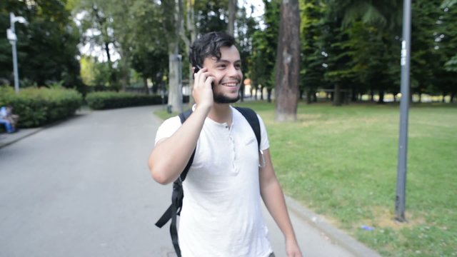 stylish young man on the phone at the park