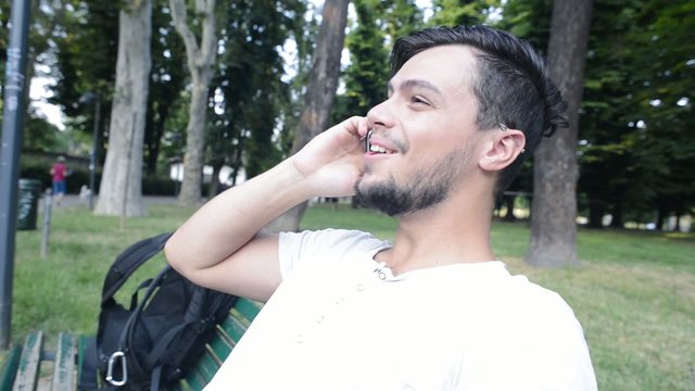 stylish young man on the phone at the park
