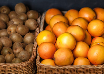 Close up of heap of oranges and kiwis