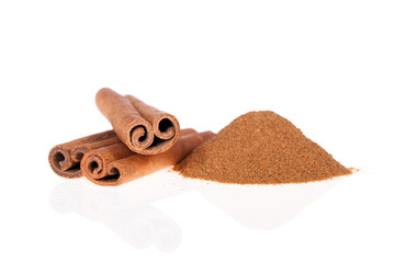 Cinnamon powder and sticks isolated on a white background.