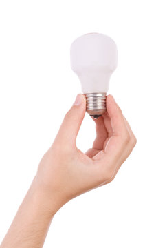 Hand holding an incandescent light bulb isolated on white.