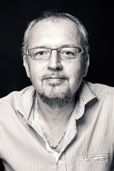 Middle age man close up portrait against black background. Black