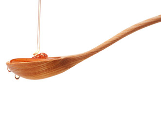 Honey dripping from a wooden honey dipper isolated on white back