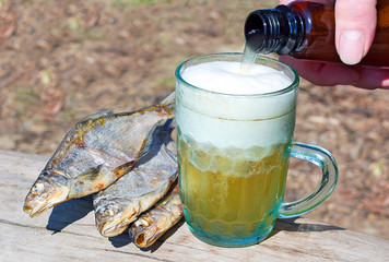 A man's hand pours a beer
